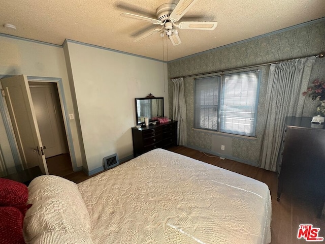 bedroom featuring ceiling fan, crown molding, wood-type flooring, and a textured ceiling