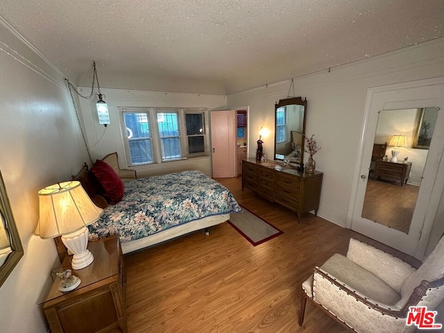 bedroom with wood-type flooring and a textured ceiling