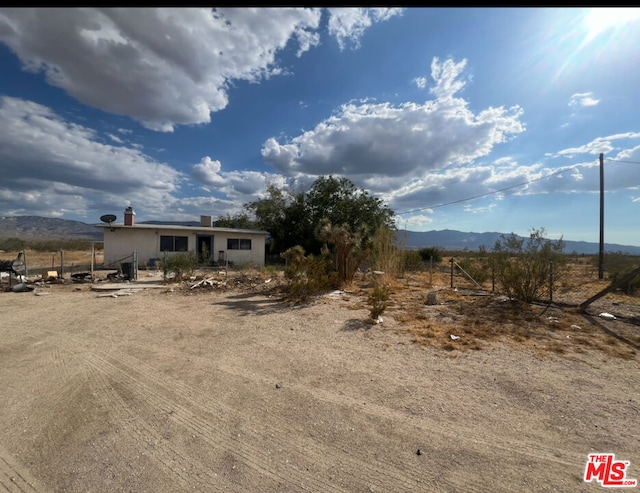 view of front of property with a mountain view and a rural view