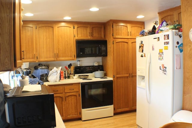 kitchen with light hardwood / wood-style floors and white appliances