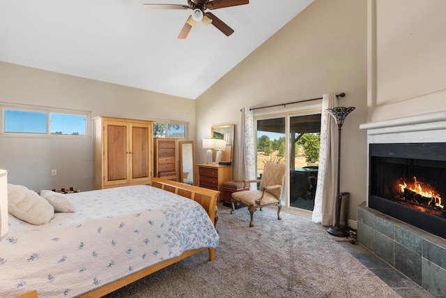 carpeted bedroom featuring ceiling fan, a tiled fireplace, access to exterior, and high vaulted ceiling