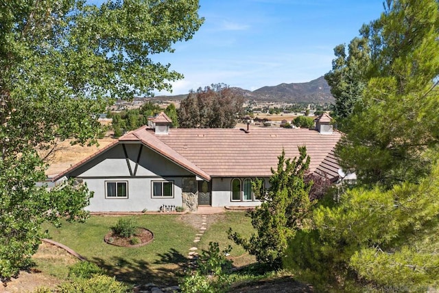 back of property featuring a yard and a mountain view