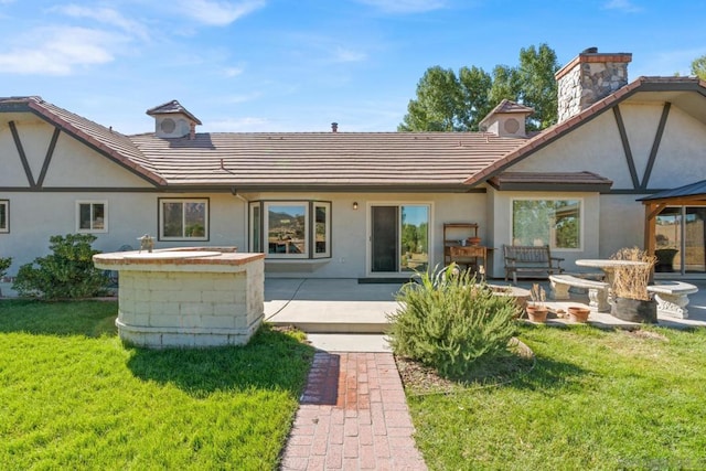 rear view of house with a patio and a yard