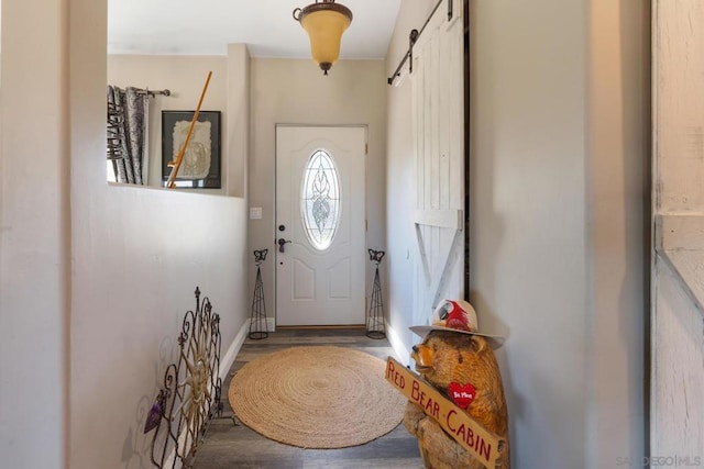 doorway to outside with a barn door and wood-type flooring