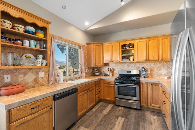 kitchen with sink, lofted ceiling, tile countertops, appliances with stainless steel finishes, and dark hardwood / wood-style flooring