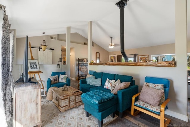 living room with a wood stove, vaulted ceiling, and hardwood / wood-style flooring