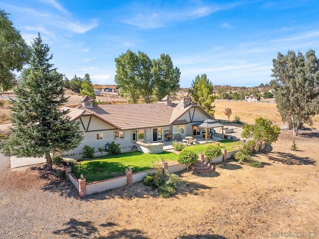 back of property with a gazebo, a lawn, and a patio