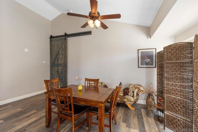 dining room featuring ceiling fan, lofted ceiling, dark hardwood / wood-style floors, and a barn door