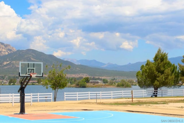 view of basketball court featuring a water and mountain view