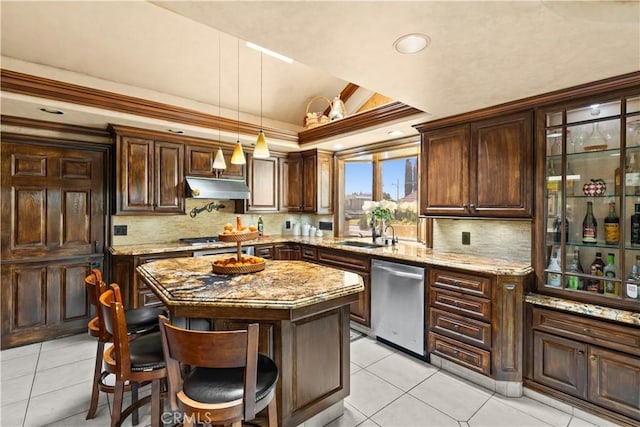 kitchen featuring a kitchen island, a raised ceiling, a kitchen bar, light stone countertops, and appliances with stainless steel finishes