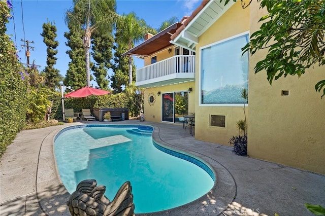 view of swimming pool featuring a hot tub and a patio area