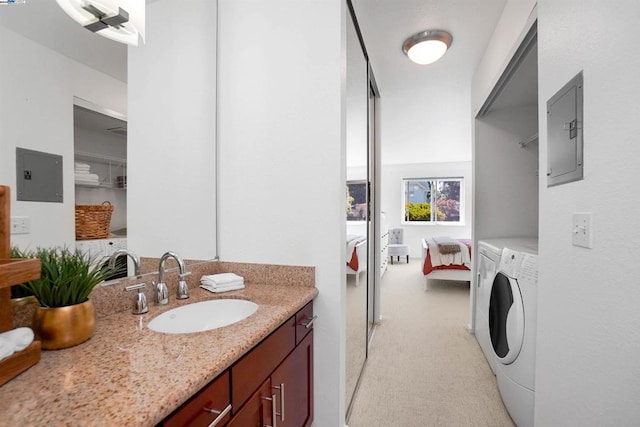 bathroom with vanity, electric panel, and washing machine and dryer