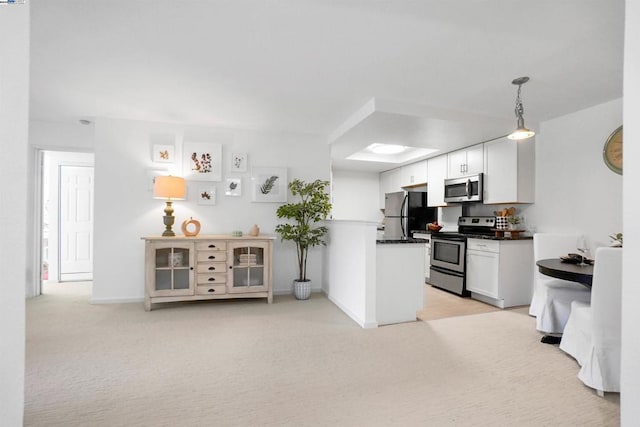 kitchen featuring light carpet, pendant lighting, stainless steel appliances, and white cabinets