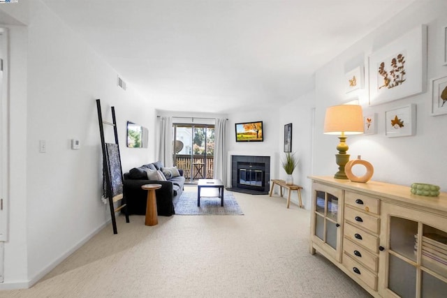 living room featuring a tile fireplace and light colored carpet