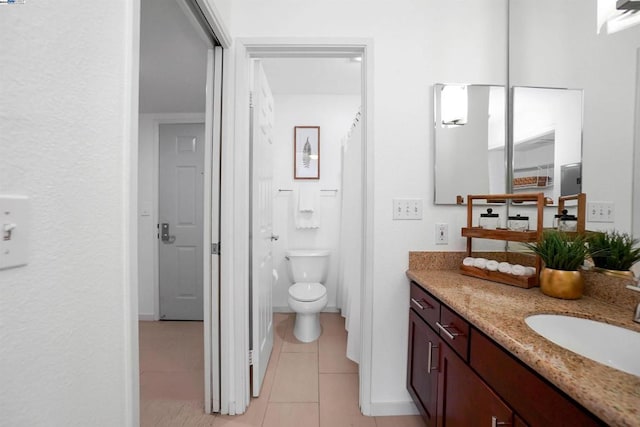 bathroom with tile patterned flooring, vanity, and toilet