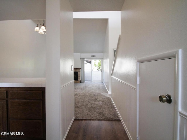 hallway featuring dark hardwood / wood-style floors and a notable chandelier