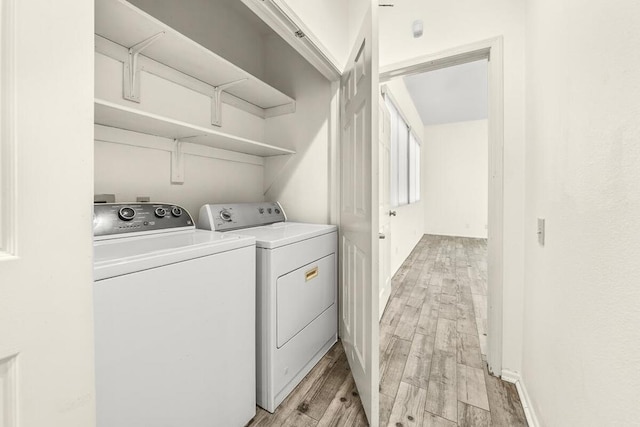 washroom featuring light wood-type flooring and washer and clothes dryer