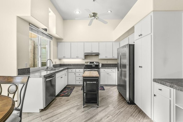 kitchen featuring light wood-type flooring, stainless steel appliances, ceiling fan, sink, and white cabinetry