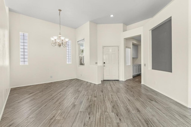 empty room with a chandelier and hardwood / wood-style flooring