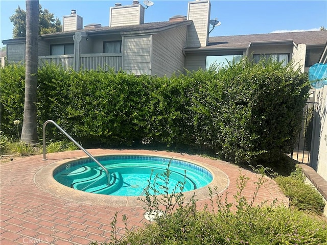 view of swimming pool with an in ground hot tub