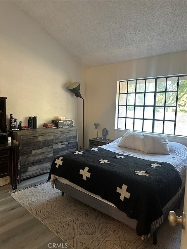 bedroom featuring wood-type flooring and a textured ceiling