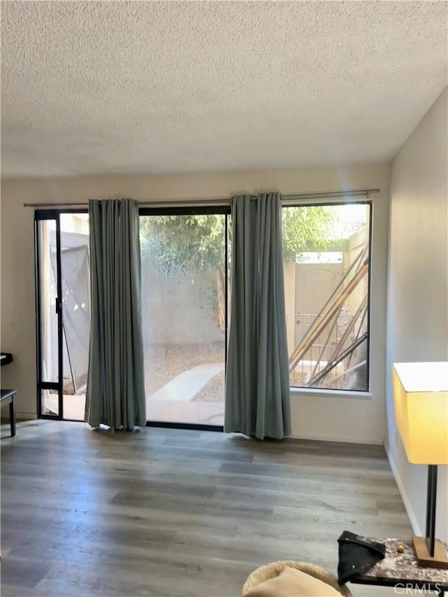 interior space with a textured ceiling and hardwood / wood-style flooring