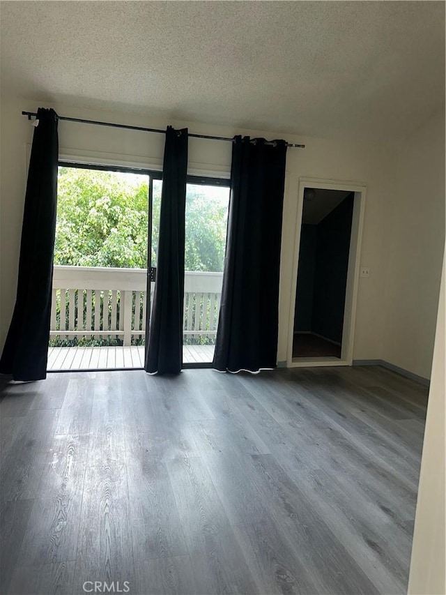 unfurnished room featuring a textured ceiling and wood finished floors