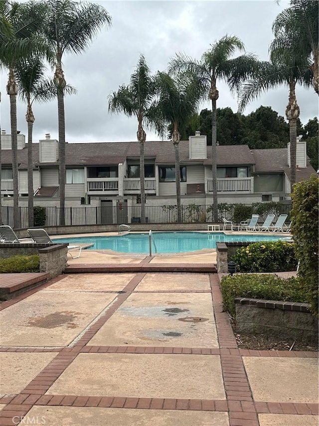 pool with fence and a patio