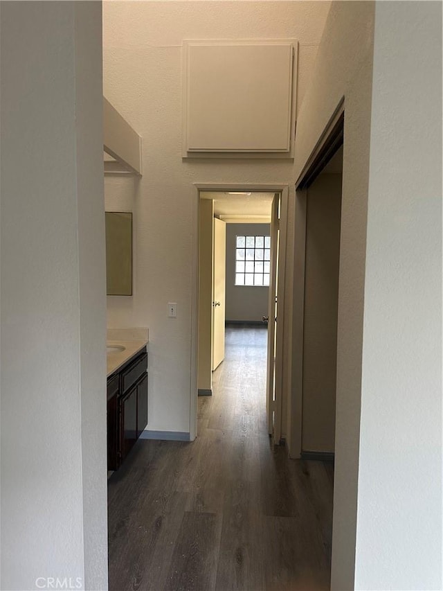 hallway featuring baseboards and wood finished floors