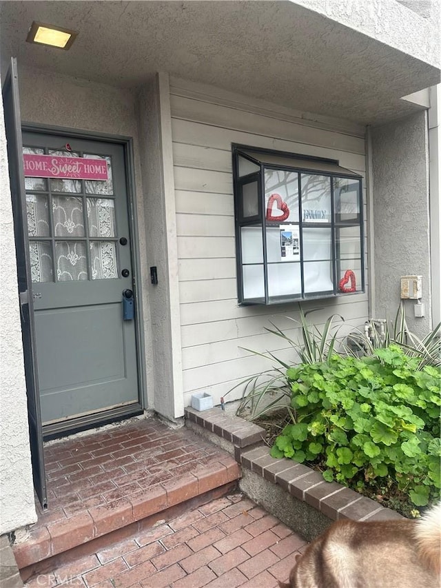 doorway to property featuring stucco siding