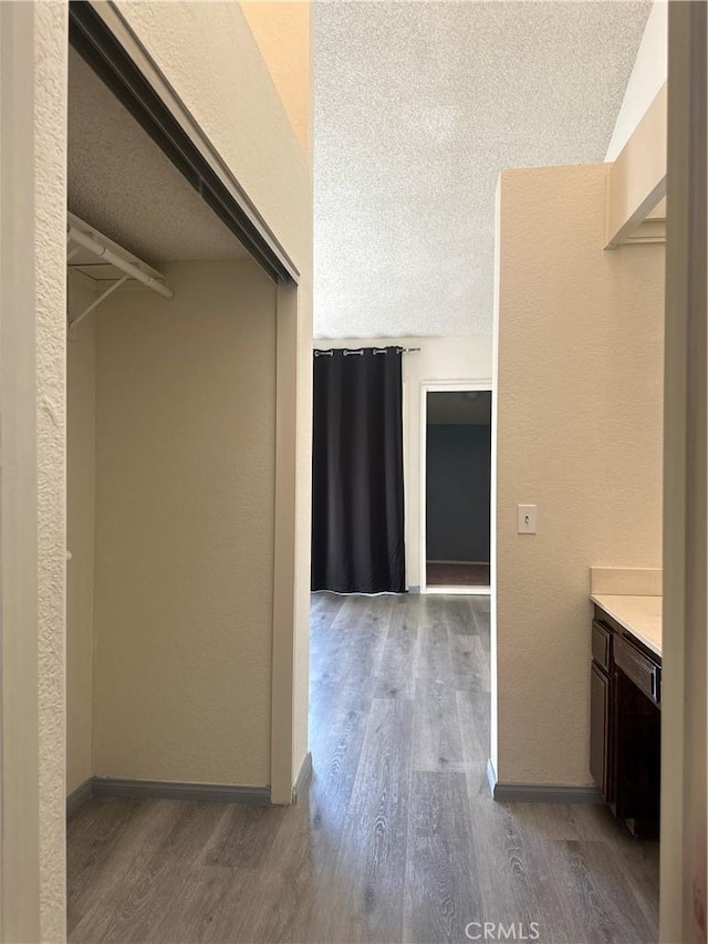 walk in closet with wood finished floors