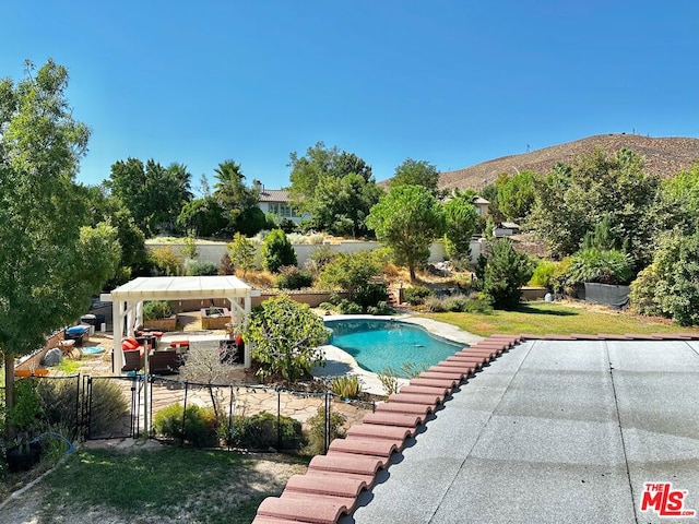 view of pool featuring a mountain view, a gazebo, a yard, and a patio