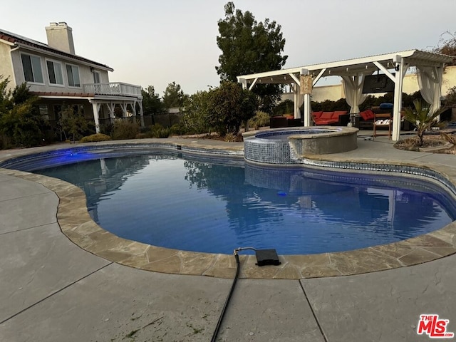 view of swimming pool featuring a patio and an in ground hot tub