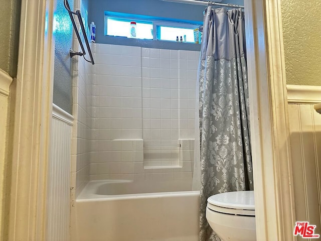 bathroom with shower / bath combo and toilet