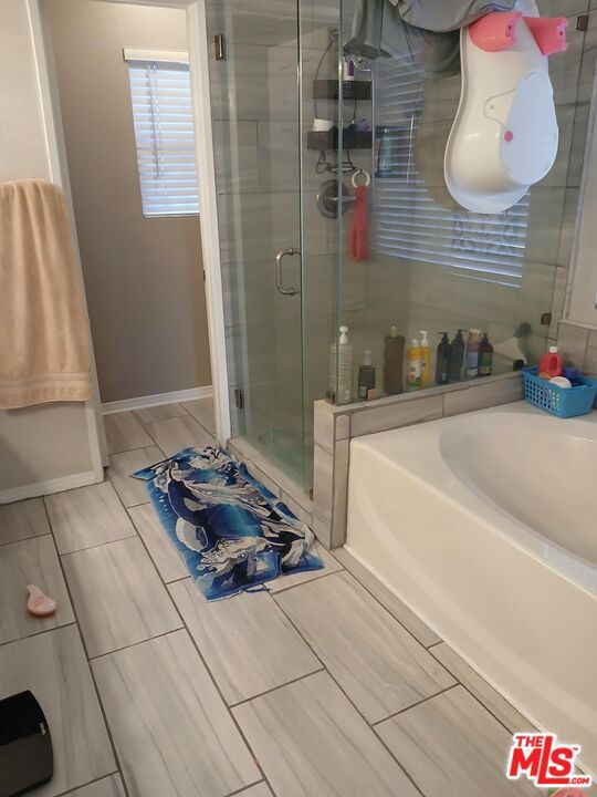 bathroom featuring shower with separate bathtub