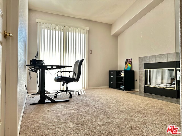 home office featuring carpet and a tiled fireplace