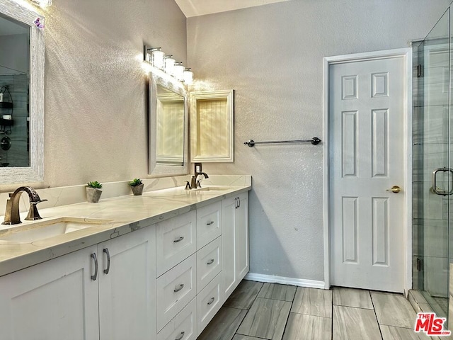 bathroom with vanity and a shower with door