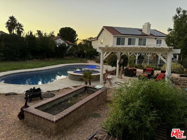 pool at dusk featuring a pergola, an outdoor living space, an in ground hot tub, and a patio