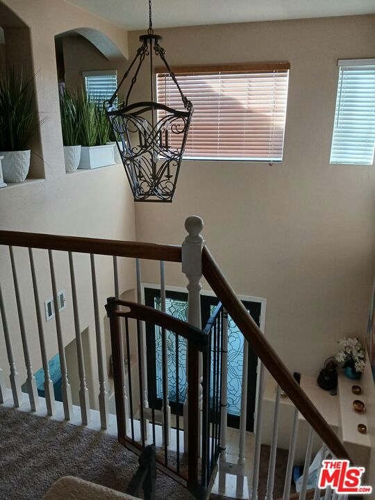 staircase with an inviting chandelier