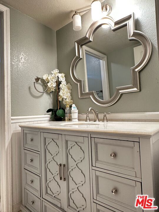 bathroom featuring a textured ceiling and vanity