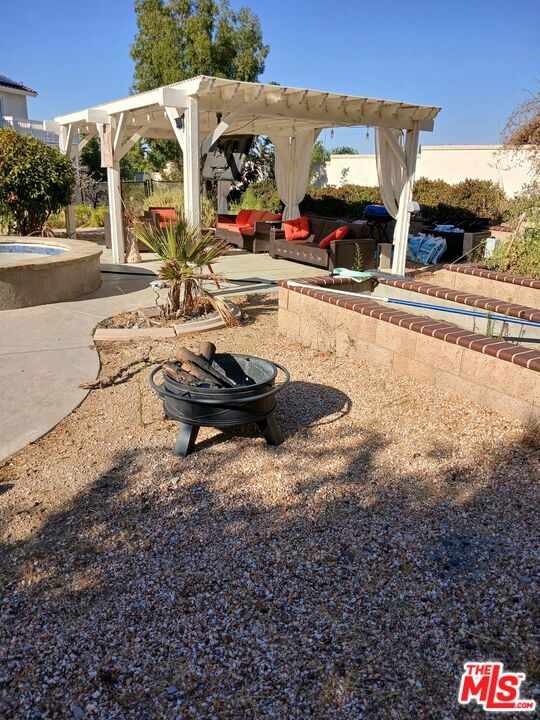 view of yard with a pergola, a patio area, and a hot tub