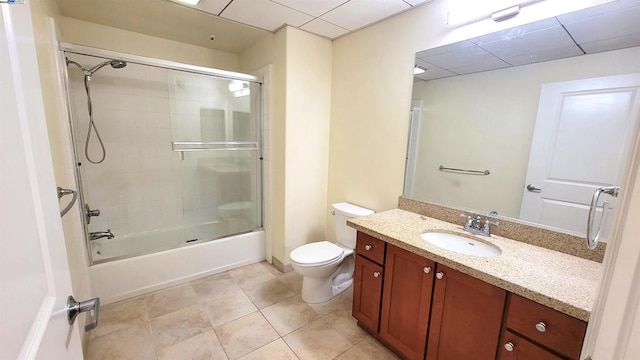 full bathroom with tile patterned flooring, shower / bath combination with glass door, vanity, and toilet