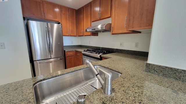 kitchen with light stone counters, appliances with stainless steel finishes, and sink