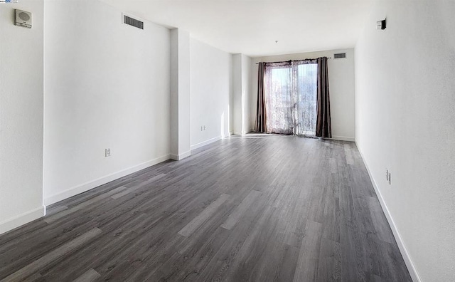 spare room with dark wood-type flooring