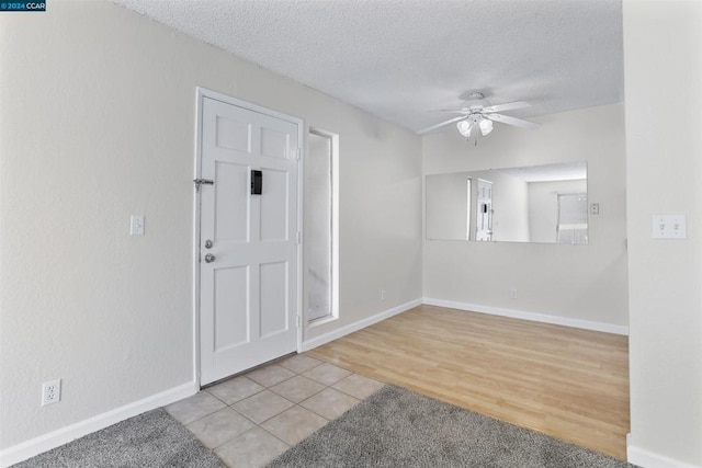 foyer with a textured ceiling, light hardwood / wood-style floors, and ceiling fan