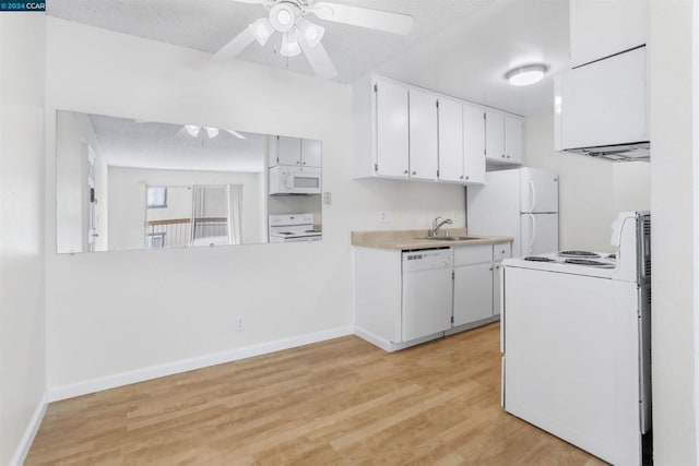 kitchen with sink, white cabinets, light hardwood / wood-style floors, and white appliances