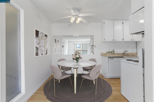 dining area featuring light wood-type flooring, ceiling fan, and sink