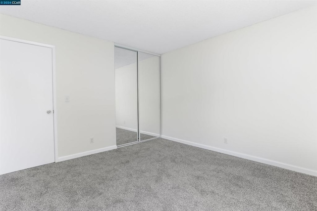 unfurnished bedroom featuring carpet floors and a closet