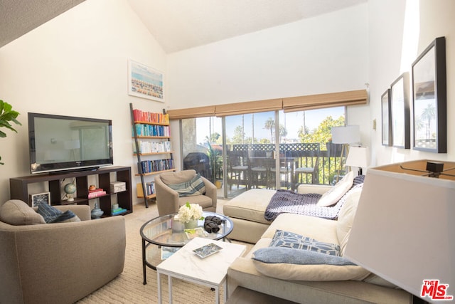 living room featuring high vaulted ceiling and light carpet