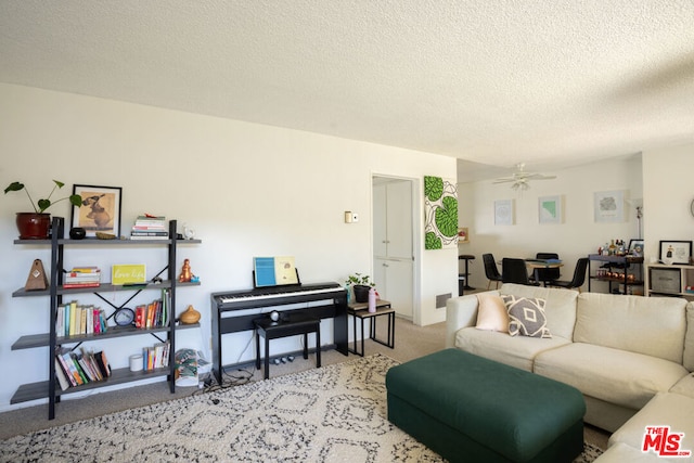 carpeted living room featuring ceiling fan and a textured ceiling